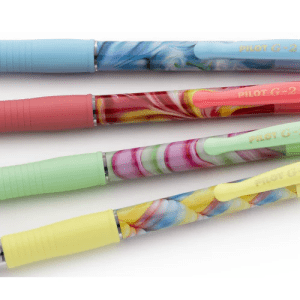 Four colourful Pilot G-2 07 retractable gel pens stacked horizontally against a white background. Each pen features a distinct pastel-coloured ribbed grip (blue, coral pink, mint green, and yellow) paired with a coordinating abstract marbled swirl design on the main barrel.