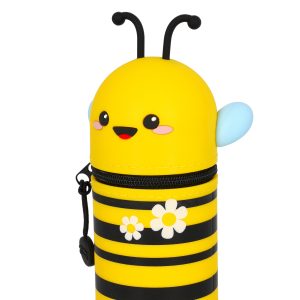 A close-up product shot of a cute, bee-shaped pencil case by Legami, isolated on a white background. The shot focuses on the top half of the pencil case, showing the bright yellow and black stripes of its body and its kawaii-style face. The bee's face has a smiling mouth, pink cheeks, and large black eyes. Its wings are light blue and its antennae are black and curly. The pencil case is zipped closed and has two white daisies with yellow centres on its side.