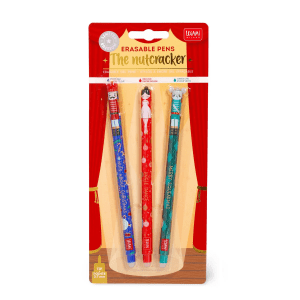 A retail blister pack containing three Christmas-themed erasable pens. The packaging features a theatrical stage curtain design in red and gold as the background for the pens. Below the main title, icons indicate the ink colors for each pen: a blue drop for "Blue Ink", a red drop for "Red Ink", and a green drop for "Green Ink". The three pens are arranged vertically in clear plastic casing: Left Pen (Blue): Features a nutcracker design, "Nuts About Christmas" text, and blue ink. Middle Pen (Red): Features a ballerina design, "Jingle Dance" text, and red ink. Right Pen (Green): Features a mouse king design, "Merry Squeakmas" text, and green ink.